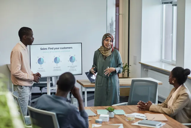 A diverse group of professionals in a business meeting discussing sales strategies. How should you build a sales enablement operating workflow?